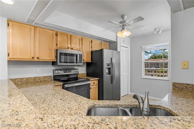 kitchen featuring light stone counters, sink, stainless steel appliances, ceiling fan, and light brown cabinetry