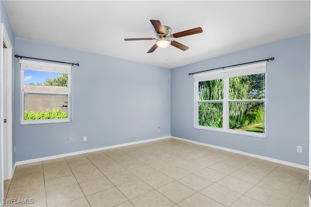 spare room featuring light tile patterned flooring, ceiling fan, and plenty of natural light