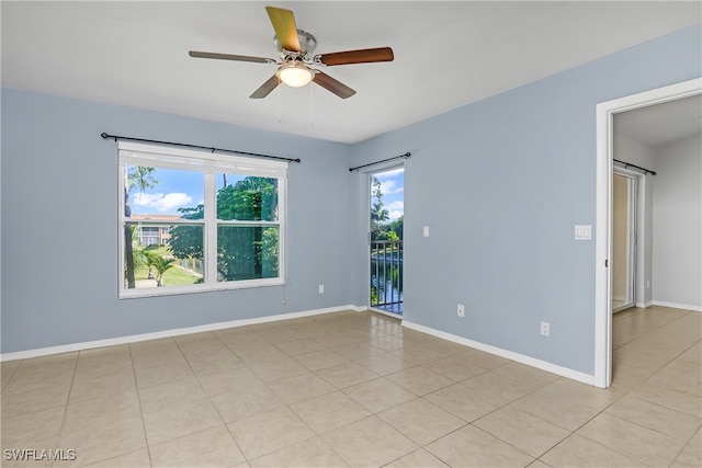 unfurnished room featuring ceiling fan, light tile patterned floors, and a healthy amount of sunlight