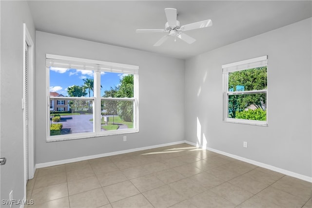 spare room with ceiling fan and light tile patterned floors