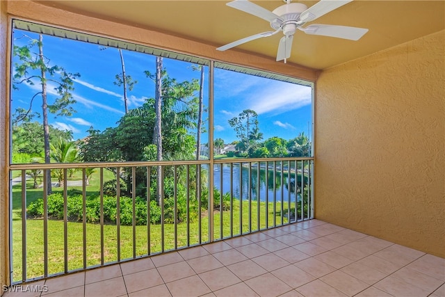 unfurnished sunroom with a water view and ceiling fan