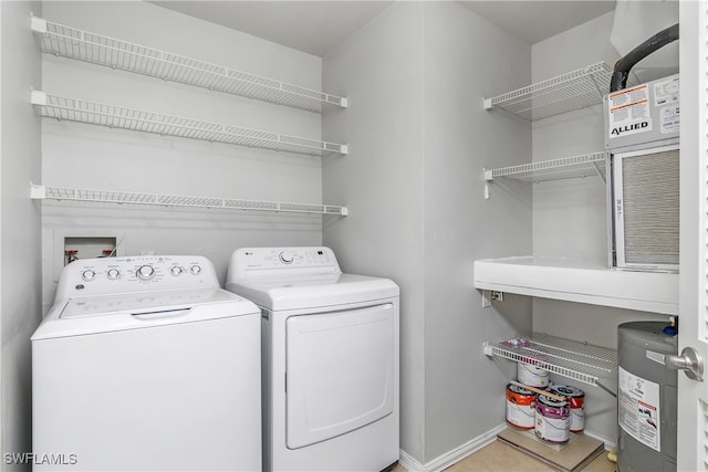 laundry room with washer and clothes dryer, light tile patterned flooring, and water heater