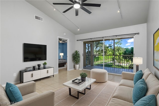 tiled living room with ceiling fan, track lighting, and high vaulted ceiling