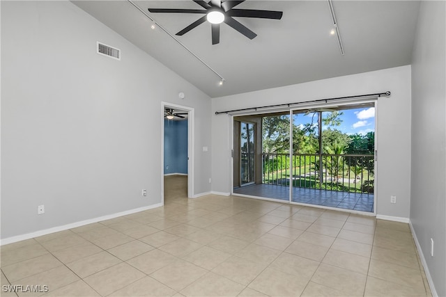 tiled spare room with ceiling fan, track lighting, and high vaulted ceiling