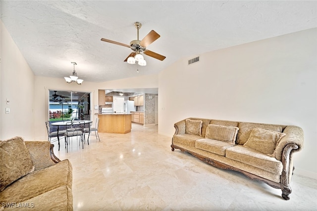 living room featuring ceiling fan with notable chandelier, lofted ceiling, and a textured ceiling