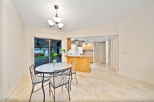 dining room featuring an inviting chandelier and a textured ceiling