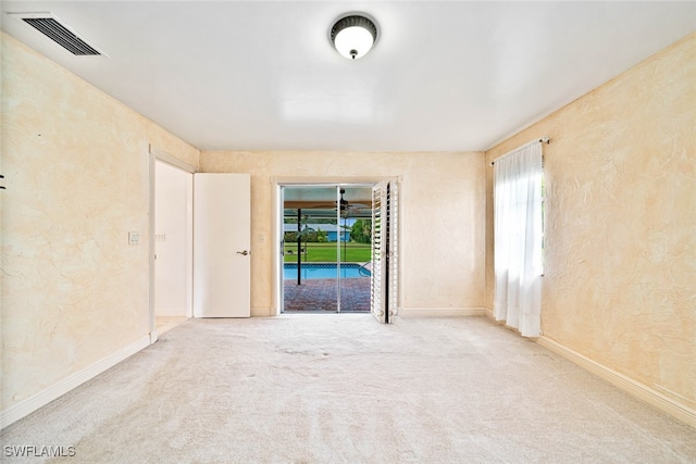 empty room featuring carpet flooring and a healthy amount of sunlight