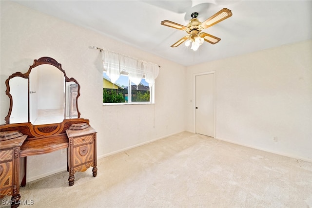 interior space with ceiling fan and light colored carpet