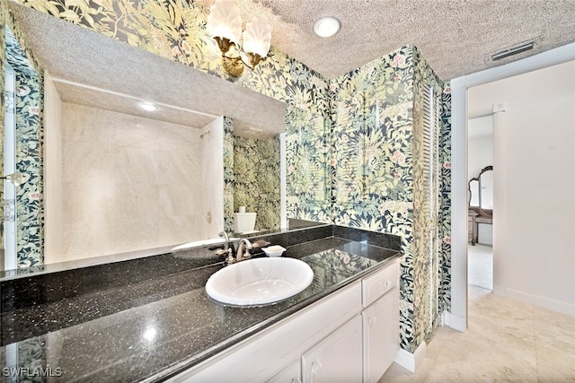 bathroom with a textured ceiling, tile patterned flooring, and vanity