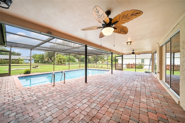 view of pool with a lanai, a patio, ceiling fan, and a yard