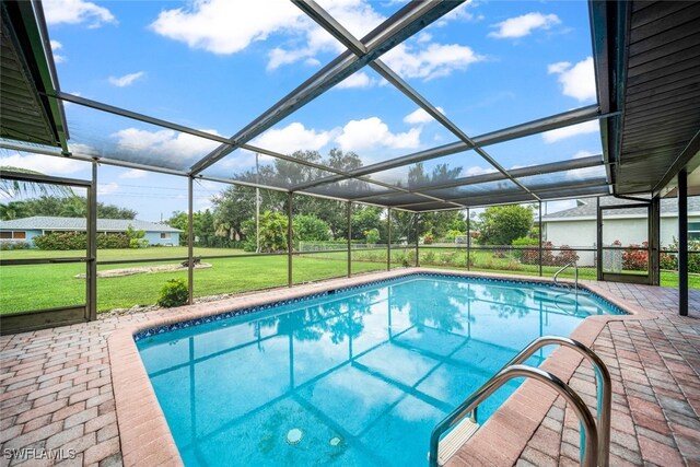 view of pool featuring a lawn, glass enclosure, and a patio area