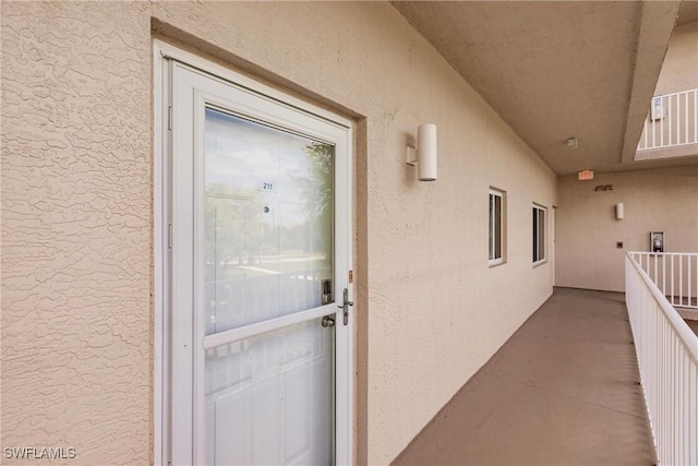 doorway to property featuring stucco siding