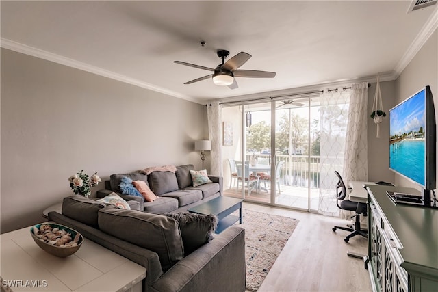 living room featuring visible vents, a ceiling fan, wood finished floors, and crown molding