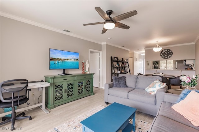 living area with ceiling fan, visible vents, light wood-style flooring, and ornamental molding