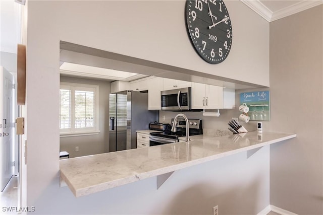 kitchen with light stone countertops, ornamental molding, appliances with stainless steel finishes, a peninsula, and white cabinets