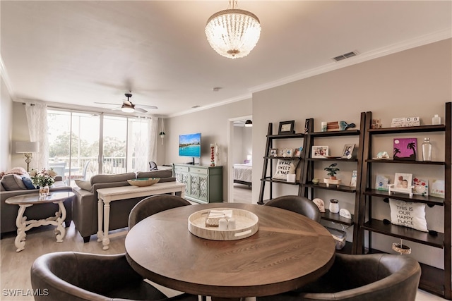 dining area featuring light wood-type flooring, visible vents, ornamental molding, and ceiling fan with notable chandelier