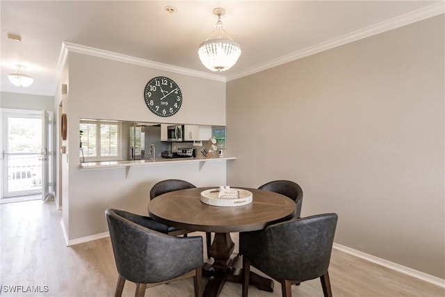 dining space with baseboards, light wood-style floors, a chandelier, and crown molding