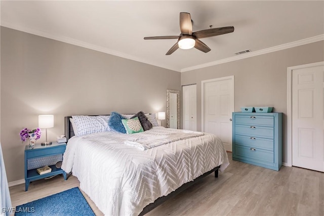 bedroom featuring ornamental molding, baseboards, visible vents, and light wood-type flooring