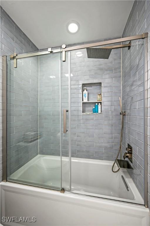 bathroom featuring shower / bath combination with glass door