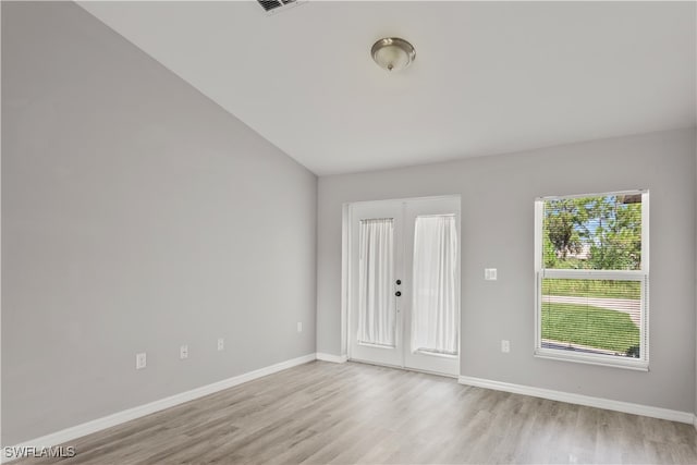 unfurnished room with light hardwood / wood-style flooring and vaulted ceiling