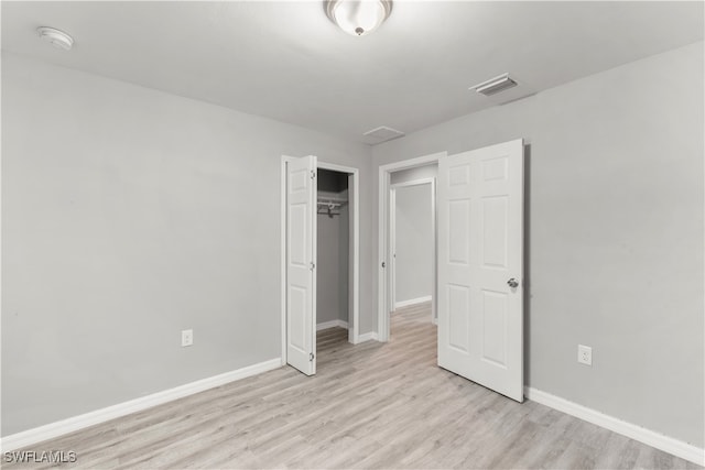 unfurnished bedroom with light wood-type flooring and a closet