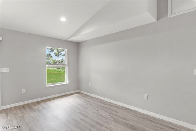 unfurnished room with lofted ceiling and light hardwood / wood-style flooring