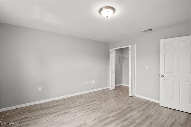 unfurnished bedroom featuring light wood-type flooring and a closet