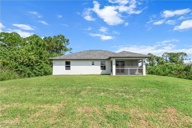 back of house featuring a sunroom and a lawn