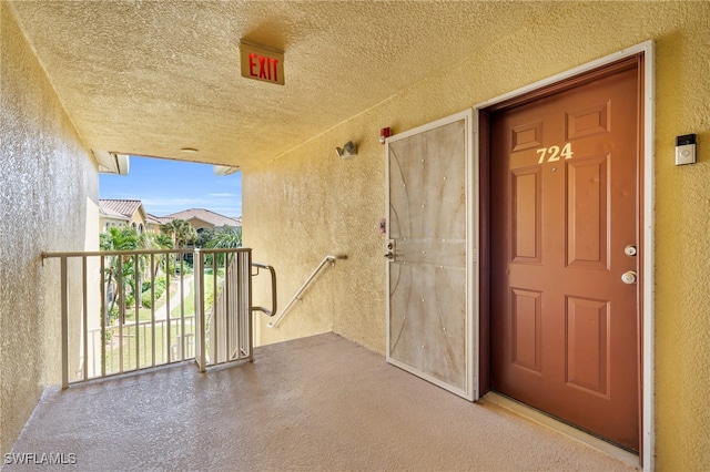 view of exterior entry featuring a balcony