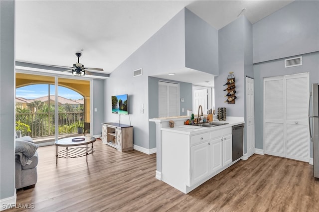 kitchen with light hardwood / wood-style floors, stainless steel appliances, sink, and white cabinets