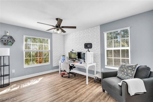 home office with light wood-type flooring and ceiling fan