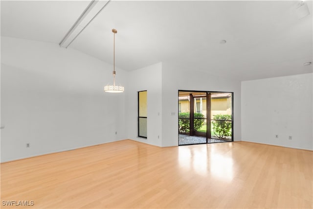 empty room with light hardwood / wood-style floors and lofted ceiling with beams