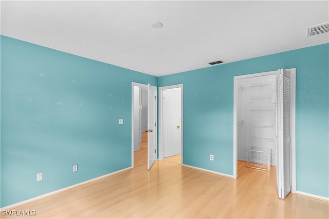 unfurnished bedroom featuring a closet and light hardwood / wood-style floors