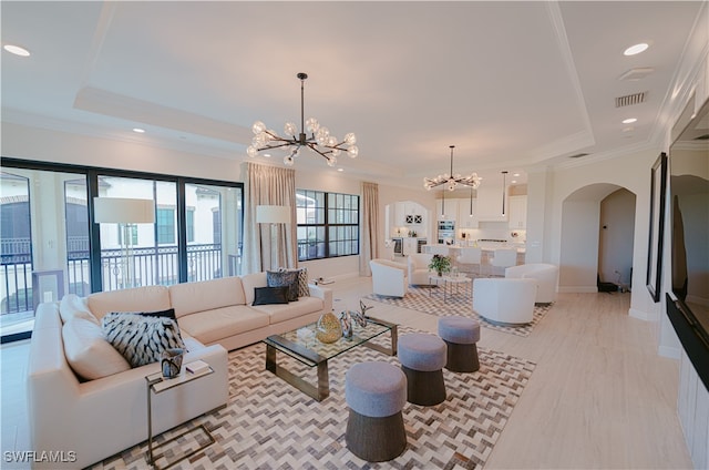 living room with a notable chandelier and crown molding