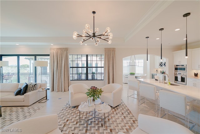 living room with a chandelier, light hardwood / wood-style flooring, plenty of natural light, and ornamental molding