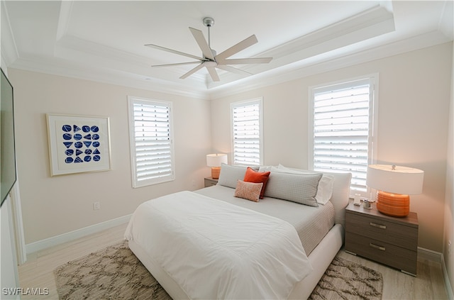 bedroom with a tray ceiling, multiple windows, and ceiling fan