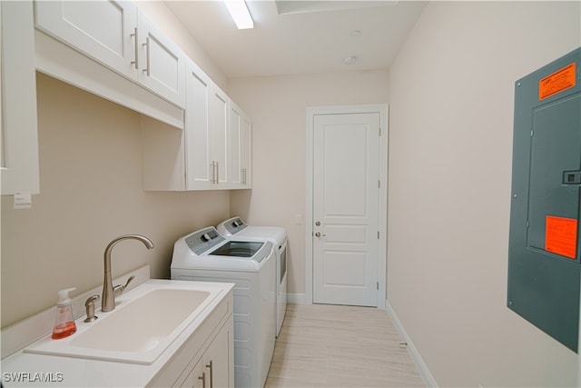 laundry room featuring electric panel, washer and clothes dryer, cabinets, and sink