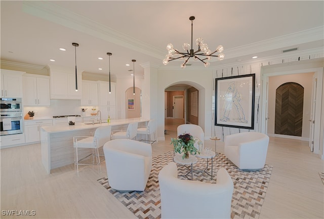 living room with crown molding, sink, and an inviting chandelier