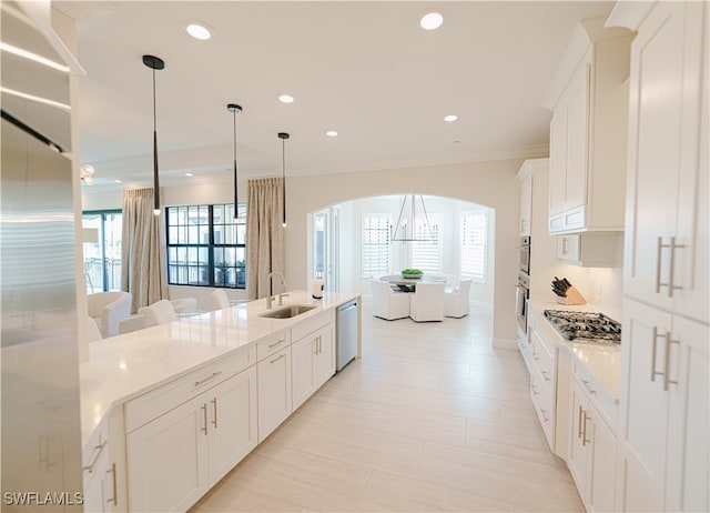 kitchen with appliances with stainless steel finishes, white cabinetry, a wealth of natural light, and sink