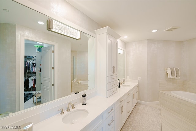 bathroom featuring vanity and a relaxing tiled tub