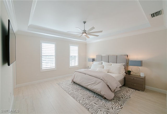 bedroom with a raised ceiling, ceiling fan, and ornamental molding