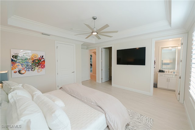 bedroom featuring ceiling fan, a raised ceiling, ornamental molding, and connected bathroom