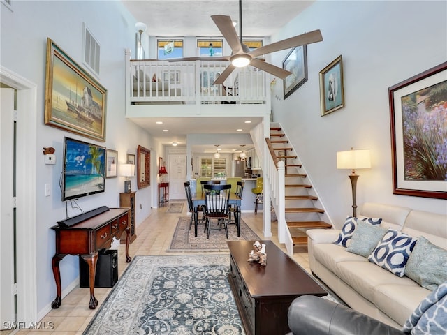 living room featuring light tile patterned flooring, a towering ceiling, and ceiling fan