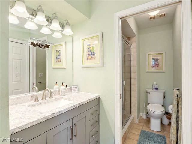 bathroom with tile patterned flooring, vanity, toilet, and an enclosed shower