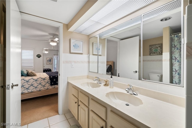 bathroom featuring ceiling fan, vanity, tile walls, tile patterned floors, and toilet