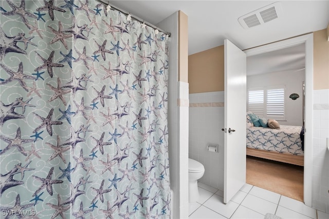 bathroom featuring tile patterned floors, tile walls, toilet, and a shower with curtain