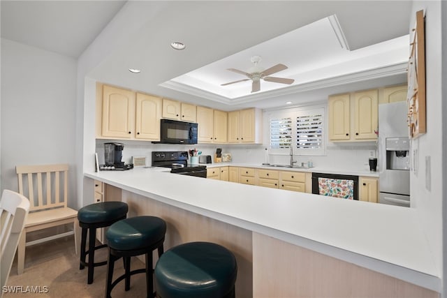 kitchen featuring ceiling fan, a kitchen breakfast bar, sink, kitchen peninsula, and black appliances