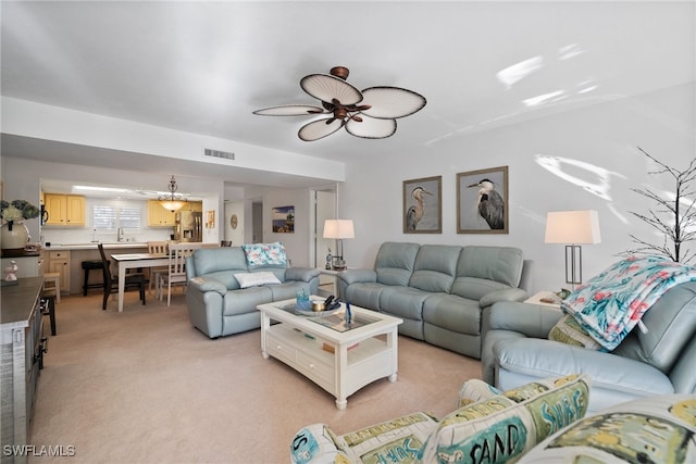 carpeted living room with sink and ceiling fan