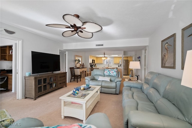 carpeted living room featuring ceiling fan