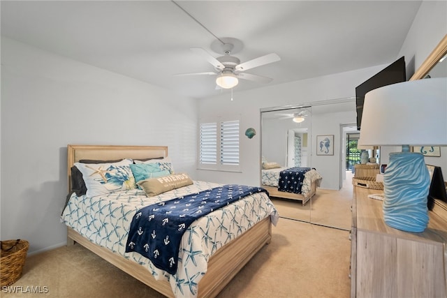 bedroom featuring ceiling fan, a closet, and light colored carpet